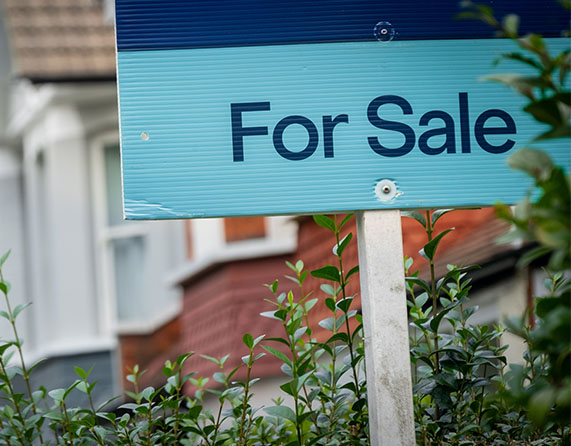 Image showing a "For sale" sign with a row of houses in the background